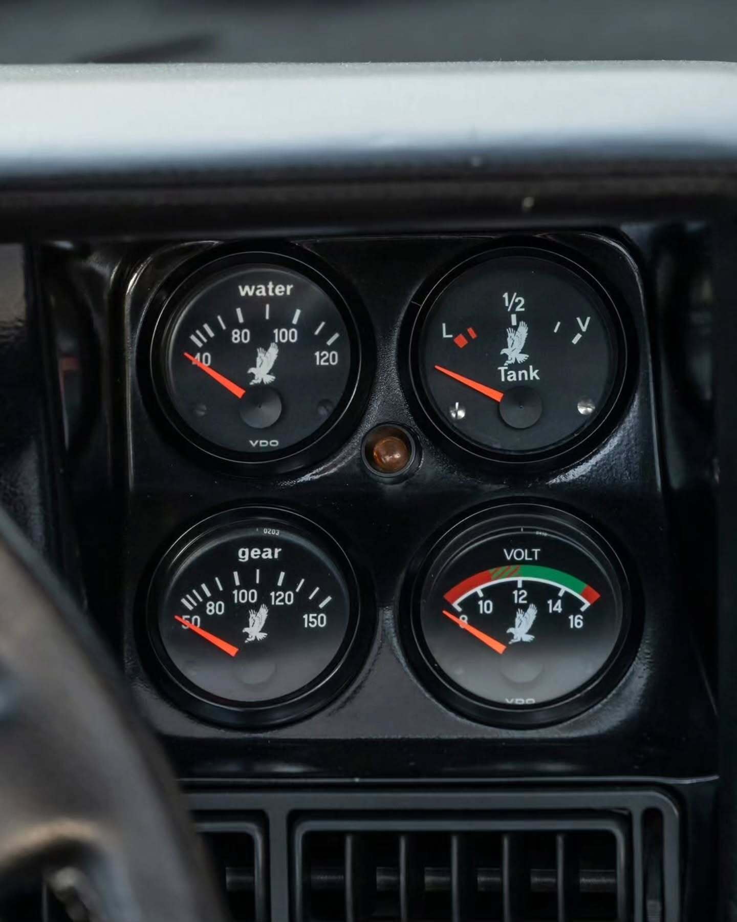 نمای جانبی ابرخودروی کلاسیک ایزدرا امپراتور 108i با رنگ نقره‌ای، آینه پیروسکوپی روی سقف و درهای بال‌کبوتری در یک فضای نمایشگاهی.