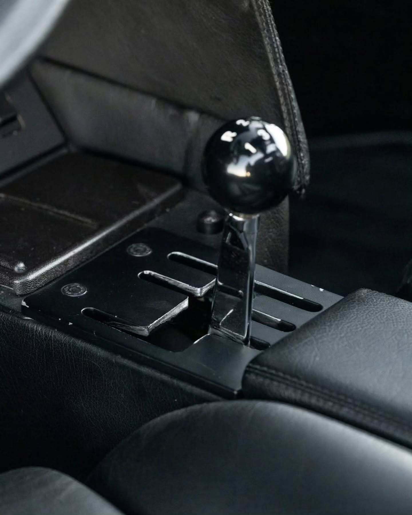 نمای جانبی ابرخودروی کلاسیک ایزدرا امپراتور 108i با رنگ نقره‌ای، آینه پیروسکوپی روی سقف و درهای بال‌کبوتری در یک فضای نمایشگاهی.