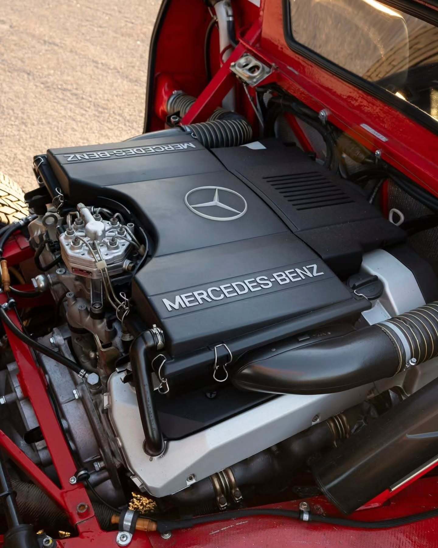 نمای جانبی ابرخودروی کلاسیک ایزدرا امپراتور 108i با رنگ نقره‌ای، آینه پیروسکوپی روی سقف و درهای بال‌کبوتری در یک فضای نمایشگاهی.